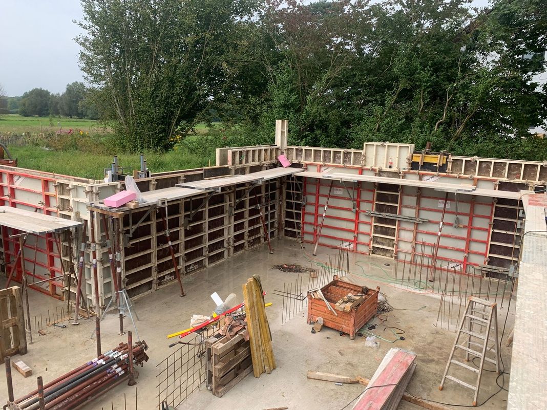 Betonkeller im Rohbau mit Schalung und Baugeräten