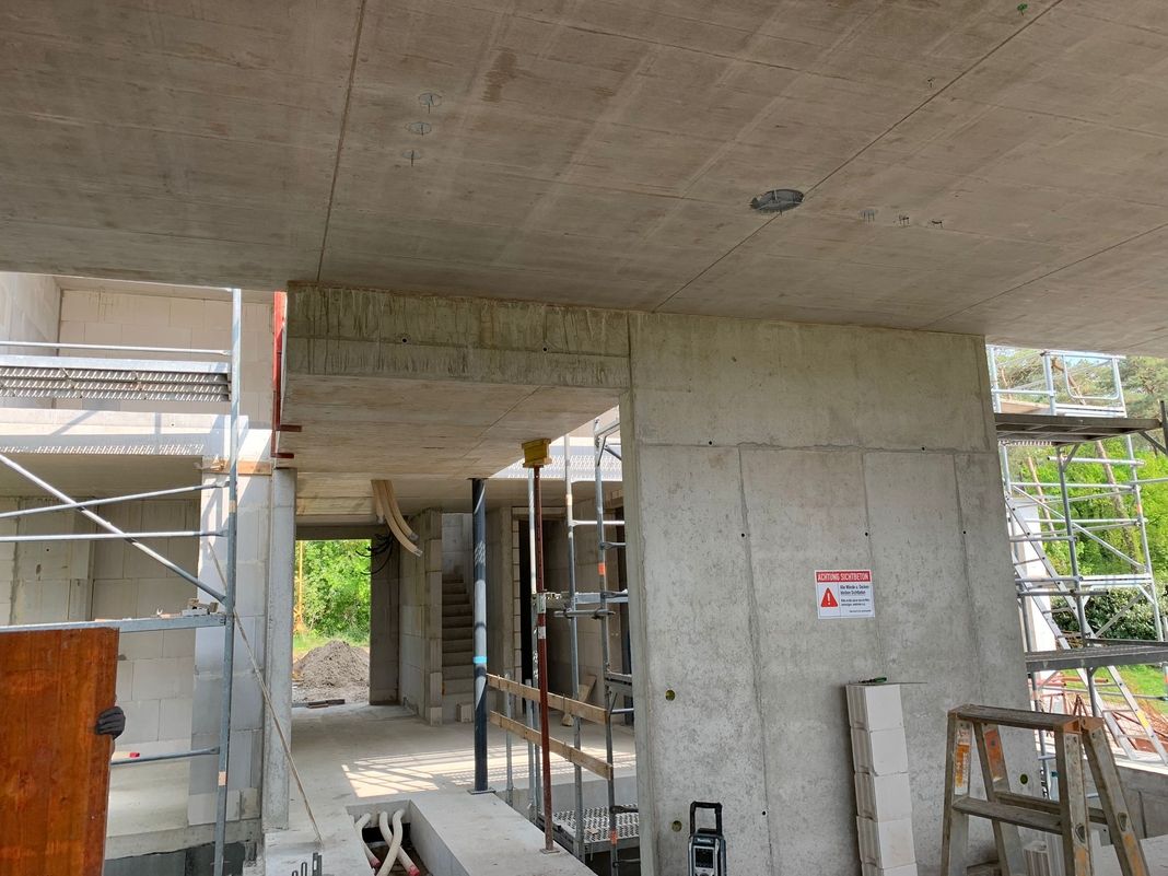 Innenansicht Rohbau mit Betonwänden und Gerüsten
